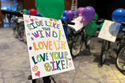 Illustration depicting a sign on the front of a bike that says 'ride like the wind love life love your bike'