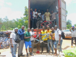 Illustration depicting a group of people standing in the back of a van holding bikes that will be donated to charity